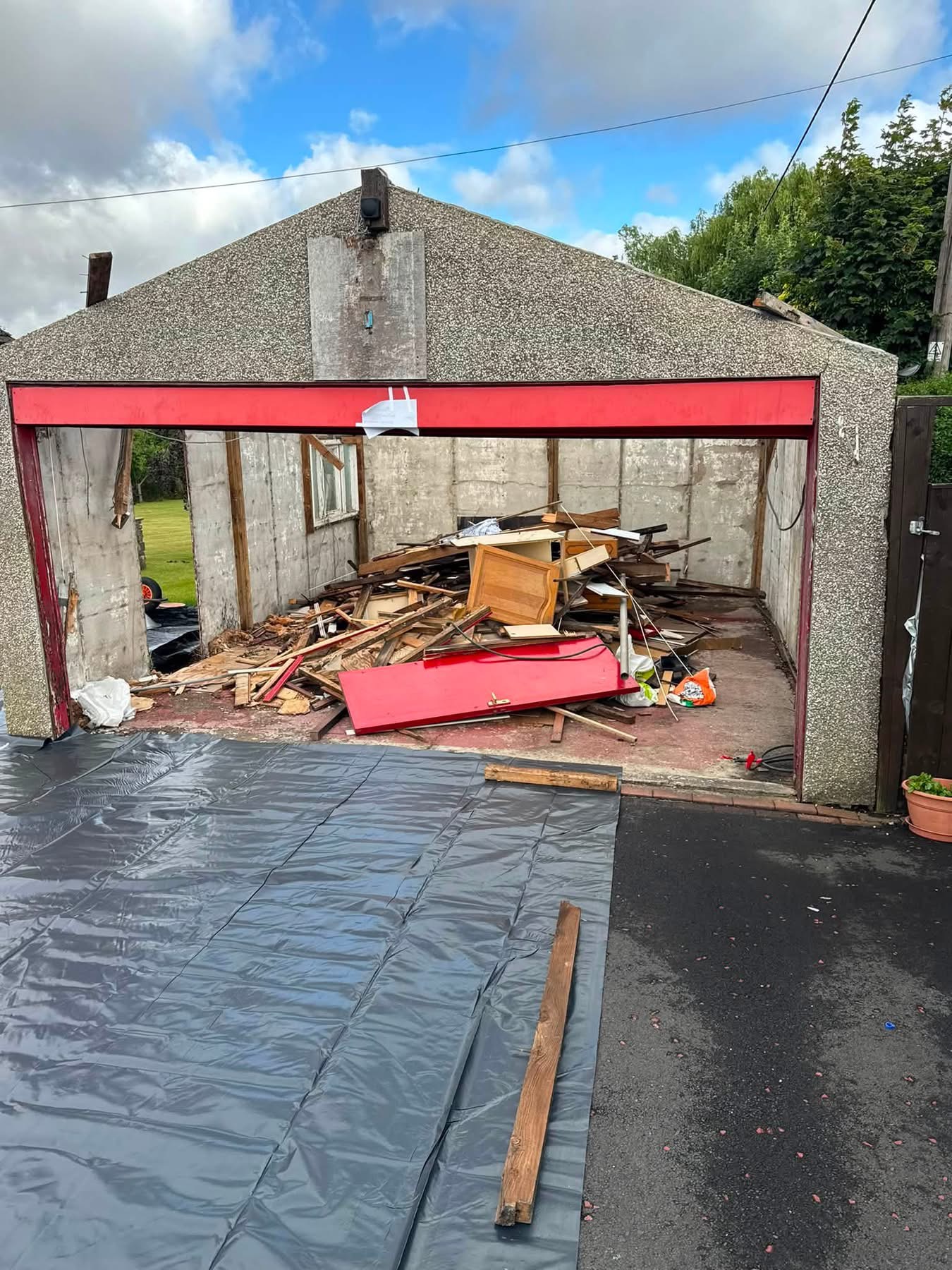 Garage filled with timber and demolition waste before clearance in Ponteland